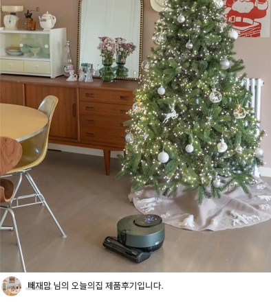 LG 코드제로 오브제컬렉션 R9 로봇청소기가 크리스마스 트리 옆 바닥에서 작동 중인 모습. 트리는 은색 장식과 조명으로 꾸며져 있으며, 하단에는 '빼재맘 님의 오늘의집 제품후기입니다.'라는 텍스트가 포함되어 사용자의 제품 경험을 강조합니다.