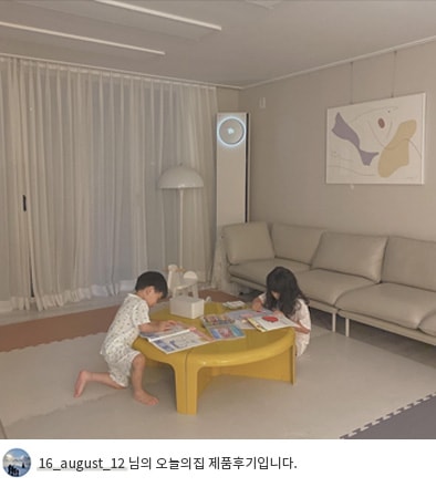 LG 휘센 오브제컬렉션 타워에어컨이 작동 중인 거실에서 어린 두 명의 아이가 노란 테이블 위에서 그림 그리고 있는 모습. 배경에는 소파와 벽걸이 그림이 있으며, 하단에는 '16_august_12 님의 오늘의집 제품후기입니다.'라는 텍스트가 포함되어 있음