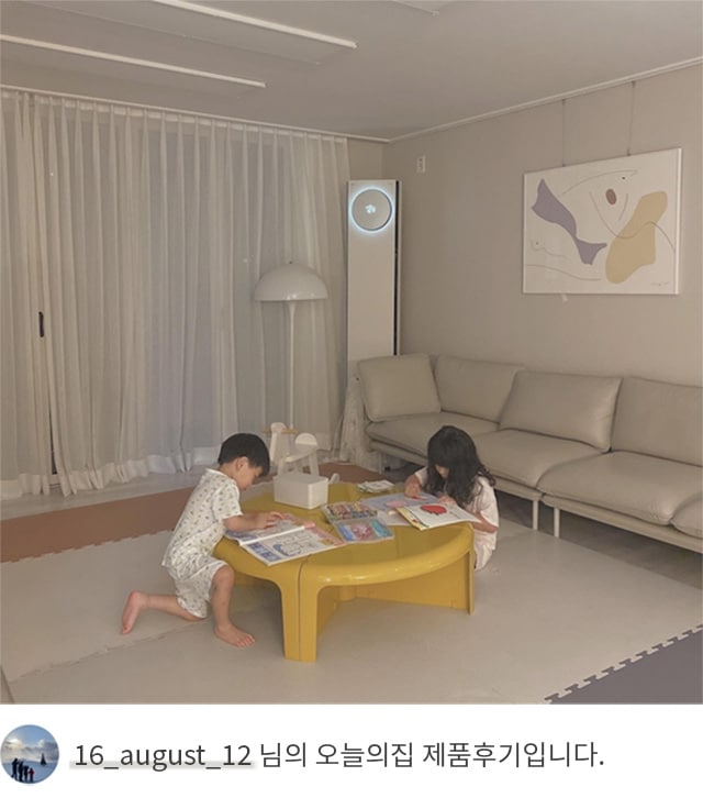 LG 휘센 오브제컬렉션 타워에어컨이 작동 중인 거실에서 어린 두 명의 아이가 노란 테이블 위에서 그림 그리고 있는 모습. 배경에는 소파와 벽걸이 그림이 있으며, 하단에는 '16_august_12 님의 오늘의집 제품후기입니다.'라는 텍스트가 포함되어 있음.