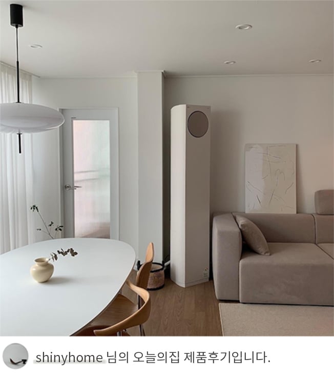 LG 휘센 오브제컬렉션 타워에어컨이 다이닝룸 옆 벽에 설치된 모습. 옆에는 화이트 톤의 타원형 식탁과 나무 소재 의자가 배치되어 있으며, 벽에는 미니멀한 그림과 도어가 설치되어 있어 심플한 인테리어가 강조됨. 하단에는 'shinyhome 님의 오늘의집 제품후기입니다.'라는 텍스트가 포함되어 있음.