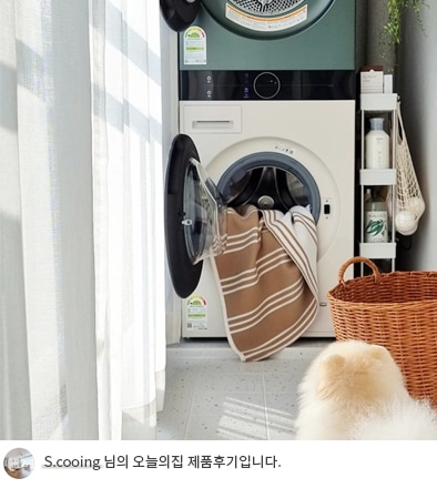LG 트롬 오브제컬렉션 워시타워 컴팩트의 세탁기와 건조기 문이 열려 있는 모습. 세탁물로 가득한 드럼 내부와 옆에 걸린 수건이 보이며, 바닥에는 강아지가 앉아 있음. 이미지 하단에는 'S.cooing 님의 오늘의집 제품후기입니다.'라는 텍스트가 포함되어 있음.