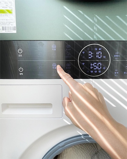 LG 트롬 오브제컬렉션 워시타워 컴팩트의 디스플레이 화면을 손가락으로 조작하고 있는 모습. 사용자의 편리한 조작 방식을 보여줌.