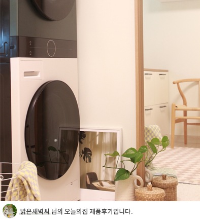 LG 트롬 오브제컬렉션 워시타워 컴팩트가 문 옆 공간에 배치되어 있으며, 모던한 디자인이 돋보입니다. 하단에는 '밝은새벽씨 님의 오늘의집 제품후기입니다.'라는 텍스트가 포함되어 있음.
