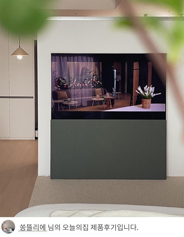  LG 올레드 오브제컬렉션 Easel TV 하단에 회색 패널이 세워져 있는 모습. TV 아래쪽에는 '쏭뜰리에 님의 오늘의집 제품후기입니다.'라는 텍스트가 포함되어 있음. TV는 실내 공간에서 예술 작품처럼 보이며, 모던한 디자인이 돋보임.
