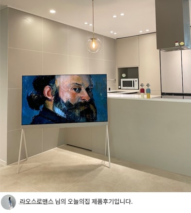 LG 올레드 오브제컬렉션 포제 TV가 주방 공간에 배치된 모습. TV 화면에는 고전적인 초상화가 표시되어 있으며, 인테리어 소품처럼 감각적인 아트 갤러리 분위기를 연출합니다. 하단에는 '라오스로맨스 님의 오늘의집 제품후기입니다.'라는 텍스트가 포함되어 있어 사용자의 제품 후기를 나타냅니다.