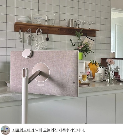 주방 선반 앞에 위치한 LG 스탠바이미의 후면이 보이며, 패브릭 소재의 세련된 뒷면 디자인이 돋보입니다. 하단에는 '자르뎅드마리 님의 오늘의집 제품후기입니다.'라는 텍스트가 포함되어 있습니다.