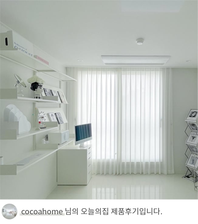 LG 휘센 주거용 시스템 에어컨이 설치된 밝은 화이트톤의 거실 혹은 방의 모습. 화면에는 모던한 가구와 선반이 조화를 이루고 있으며, 커튼이 설치된 창문을 통해 환한 채광이 들어옴. 하단에는 'cocoahome 님의 오늘의집 제품후기입니다.'라는 텍스트가 포함되어 있음. 