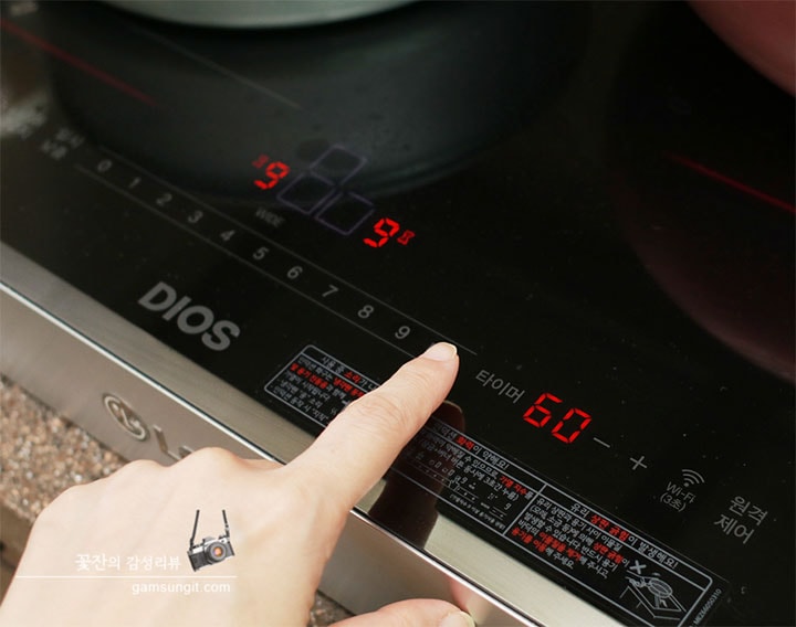 LG 디오스 인덕션의 조작부를 가까이에서 촬영한 이미지로, 화력이 9단계로 설정되어 있으며, 디스플레이에 현재 온도와 설정된 화력이 표시되어 있음
