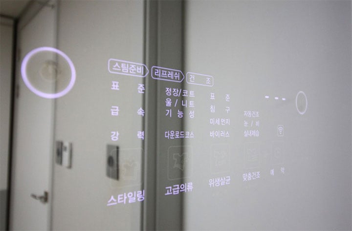 LG 스타일러 도어 패널에 비친 디지털 화면으로, '스타일링', '고급의류', '위생살균' 등의 코스 옵션과 설정 정보가 표시되어 있음