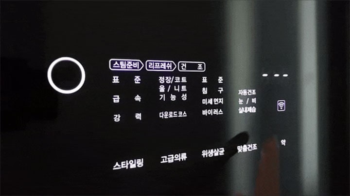 어두운 환경에서 촬영된 LG 스타일러 디지털 패널의 일부 화면으로, '스타일링', '맞춤건조', '실내제습' 등의 코스 옵션이 표시