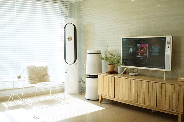 LG 퓨리케어 360° 공기청정기와 타워형 에어컨이 함께 배치된 거실 전경