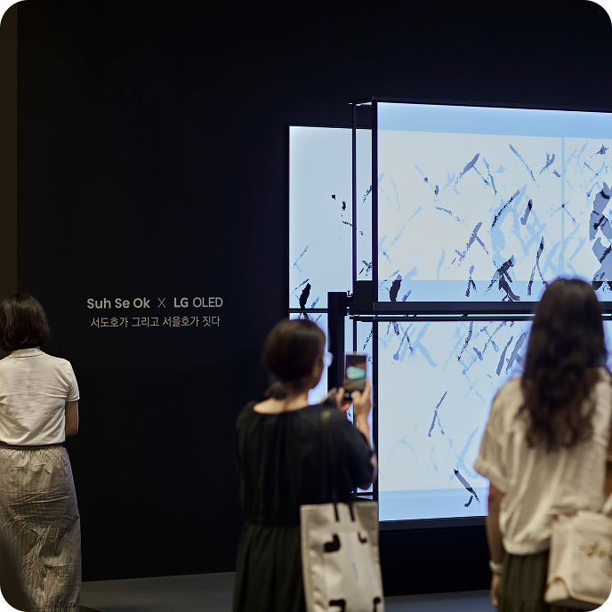 전시장 내부, 여러 대의 OLED 디스플레이를 연결한 설치 작품. 흑백 추상 이미지가 화면 전체에 재생됨