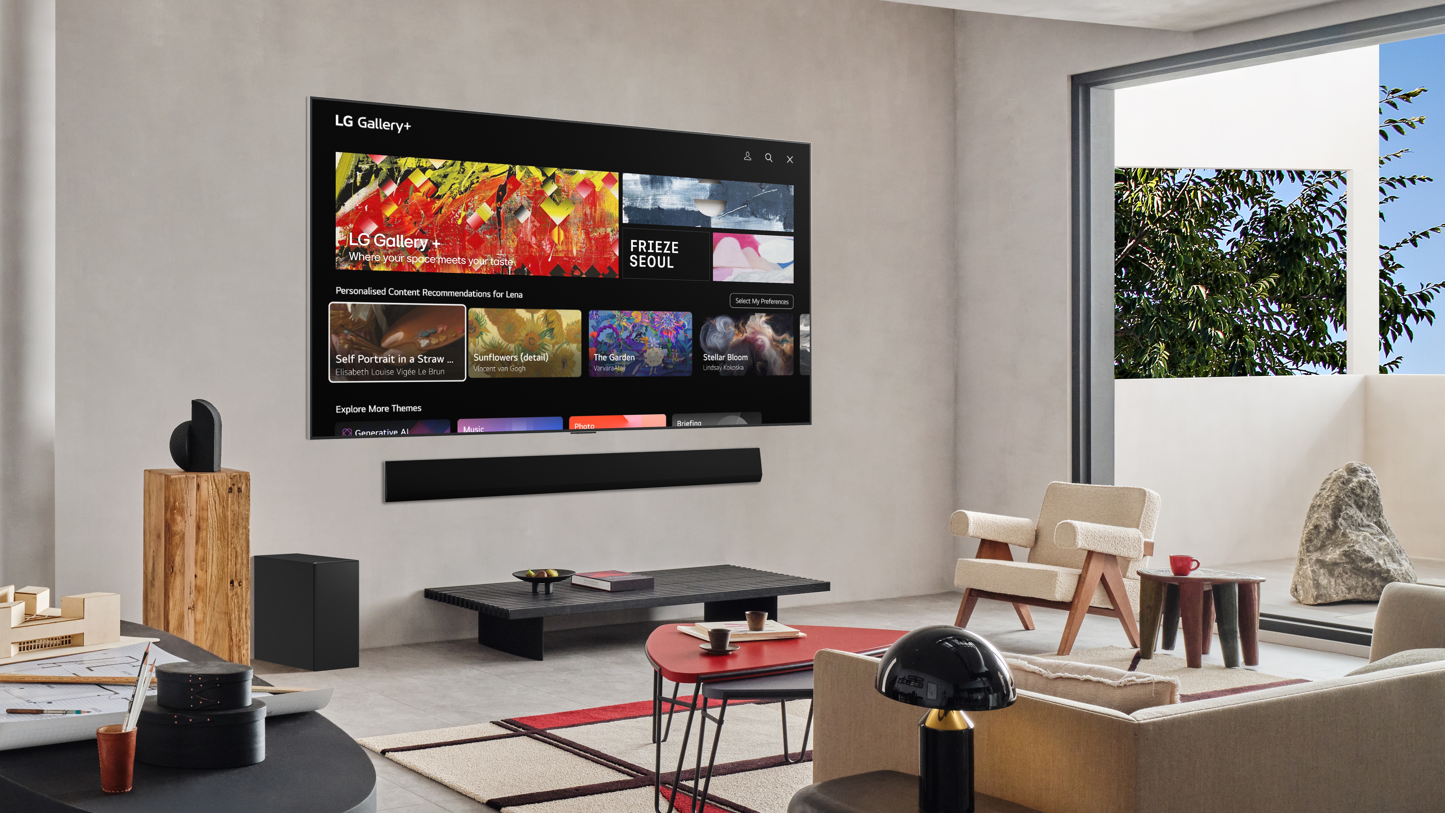 현대적인 거실 벽에 설치된 LG OLED TV에 LG Gallery+ 서비스 메인 화면이 보이며, 상단에는 ‘FRIEZE SEOUL’ 배너와 작품 이미지가, 하단에는 맞춤형 예술 콘텐츠 카드들이 표시된 모습