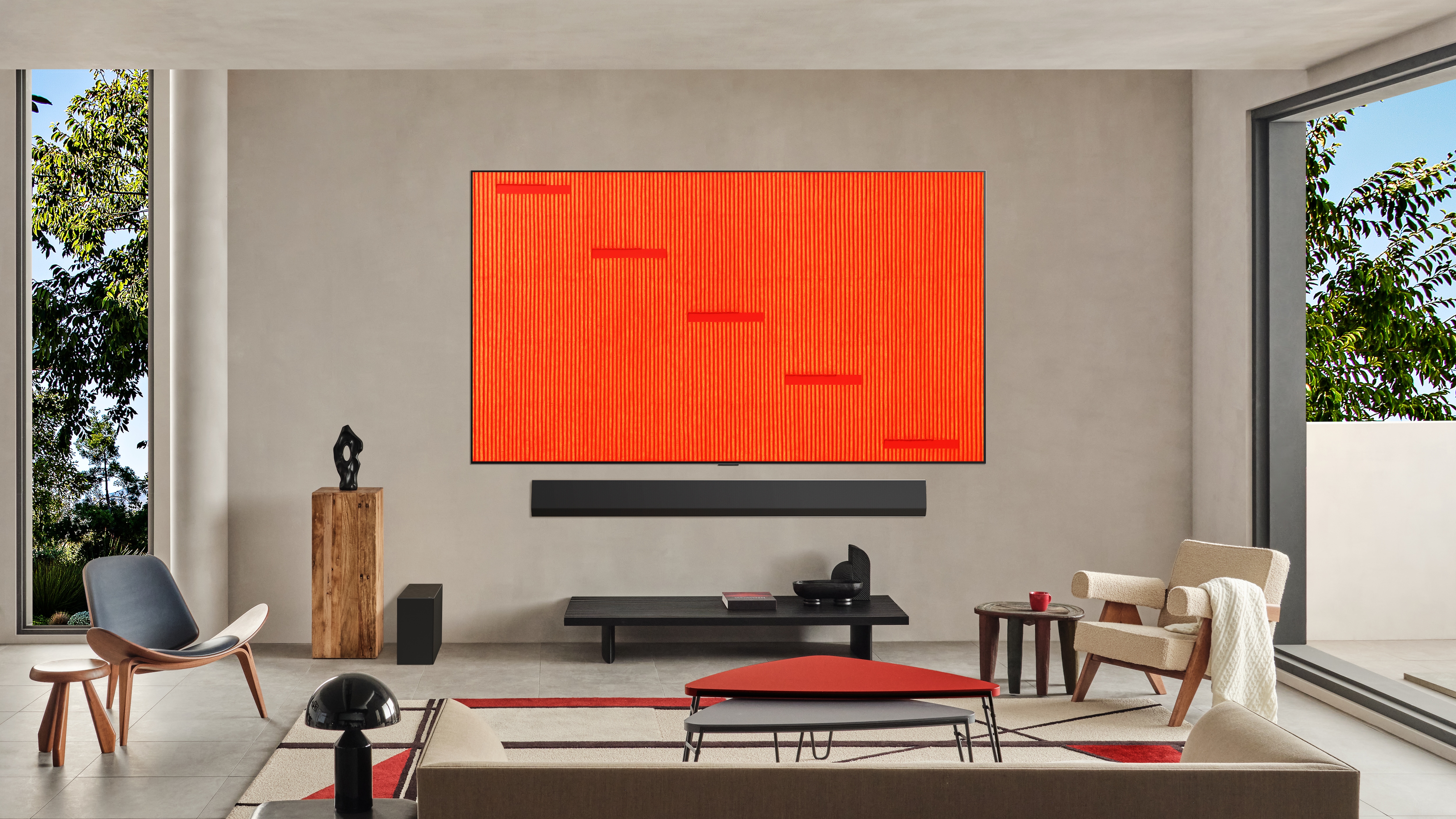 거실 벽에 설치된 LG OLED TV에 주황색 세로 패턴과 사각 블록이 배열된 추상 작품이 TV 화면에 가득찬 모습. 미니멀한 가구와 큰 창으로 들어오는 자연광이 어우러져 갤러리 같은 분위기를 연출함