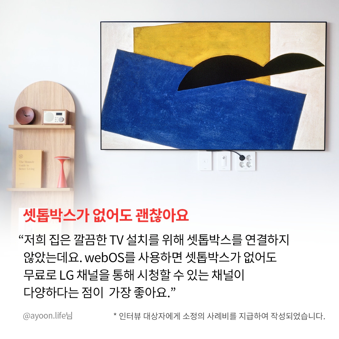 거실 벽에 설치된 TV 화면에 추상적인 예술 작품이 표시된 모습. TV 아래쪽 전기 콘센트와 연결된 케이블이 보이며, 왼쪽에는 작은 원목 선반이 배치되어 있음. 하단에는 “셋톱박스가 없어도 괜찮아요”라는 강조된 문구와 함께, LG webOS를 사용하면 셋톱박스 없이도 무료 LG 채널을 시청할 수 있다는 설명이 포함됨.