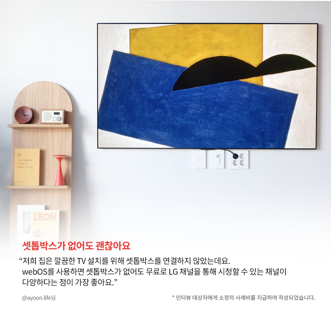 거실 벽에 설치된 TV 화면에 추상적인 예술 작품이 표시된 모습. TV 아래쪽 전기 콘센트와 연결된 케이블이 보이며, 왼쪽에는 작은 원목 선반이 배치되어 있음. 하단에는 “셋톱박스가 없어도 괜찮아요”라는 강조된 문구와 함께, LG webOS를 사용하면 셋톱박스 없이도 무료 LG 채널을 시청할 수 있다는 설명이 포함됨.