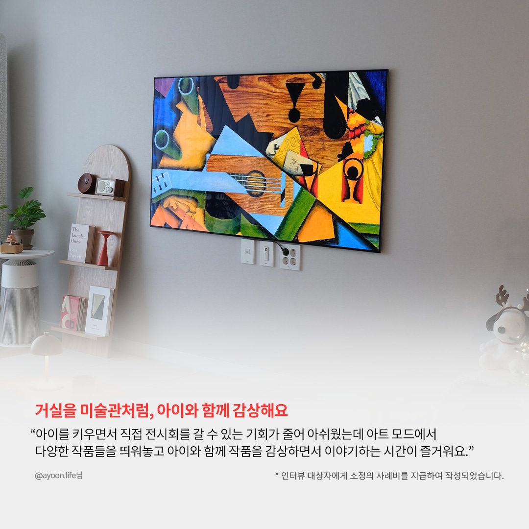 TV 화면에 색감이 풍부한 추상적인 예술 작품이 표시된 거실 공간. 왼쪽에는 나무 선반 위에 책과 장식품이 놓여 있으며, 하단에는 '거실을 미술관처럼, 아이와 함께 감상해요'라는 강조된 문구와 함께, LG webOS의 아트 모드를 활용해 다양한 작품을 감상할 수 있다는 사용자 리뷰가 포함됨.