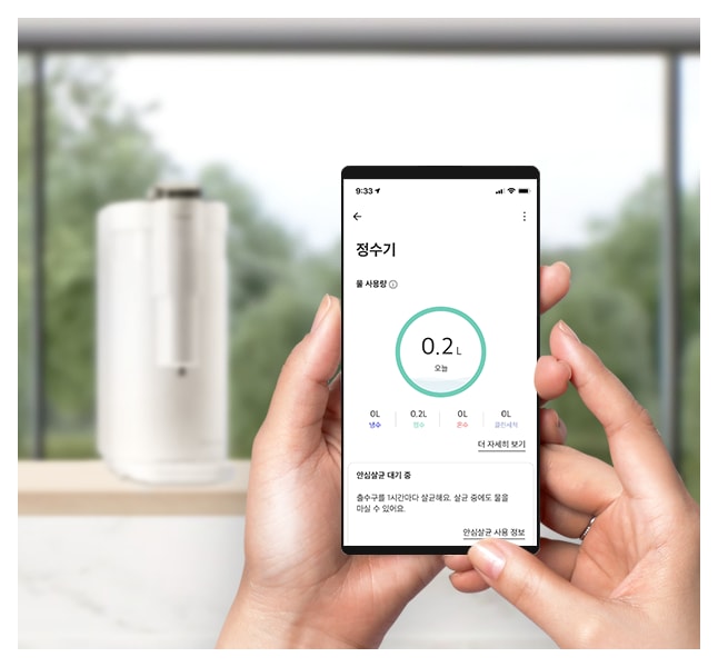 스마트폰 화면에 물 섭취량을 기록하는 앱이 표시된 모습으로, 손으로 스마트폰을 조작하며 뒤에는 정수기가 놓여 있는 배경이 있는 이미지