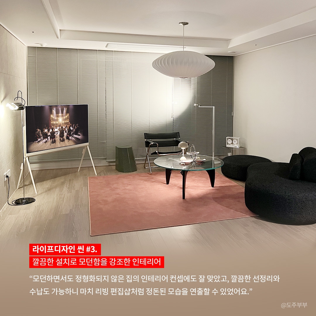 모던한 리빙룸에서 LG OLED TV가 세련된 조명과 함께 배치되어 고급스러운 분위기를 연출하는 모습입니다. TV는 오케스트라 공연을 재생하며, 정돈된 선 정리와 리빙 편집샵 같은 느낌을 강조한 인테리어를 보여줍니다.