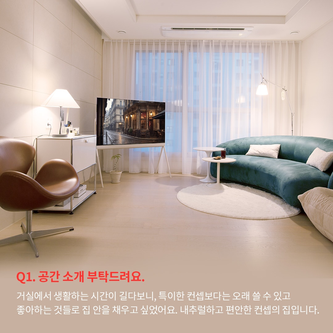 넓은 창과 따뜻한 조명 아래, 내추럴하고 편안한 분위기를 강조한 거실 공간입니다. 인터뷰 내용에서는 거실을 오래 쓸 수 있는 공간으로 구성하며, 개인의 취향과 편안함을 중시한 디자인 선택을 언급합니다.