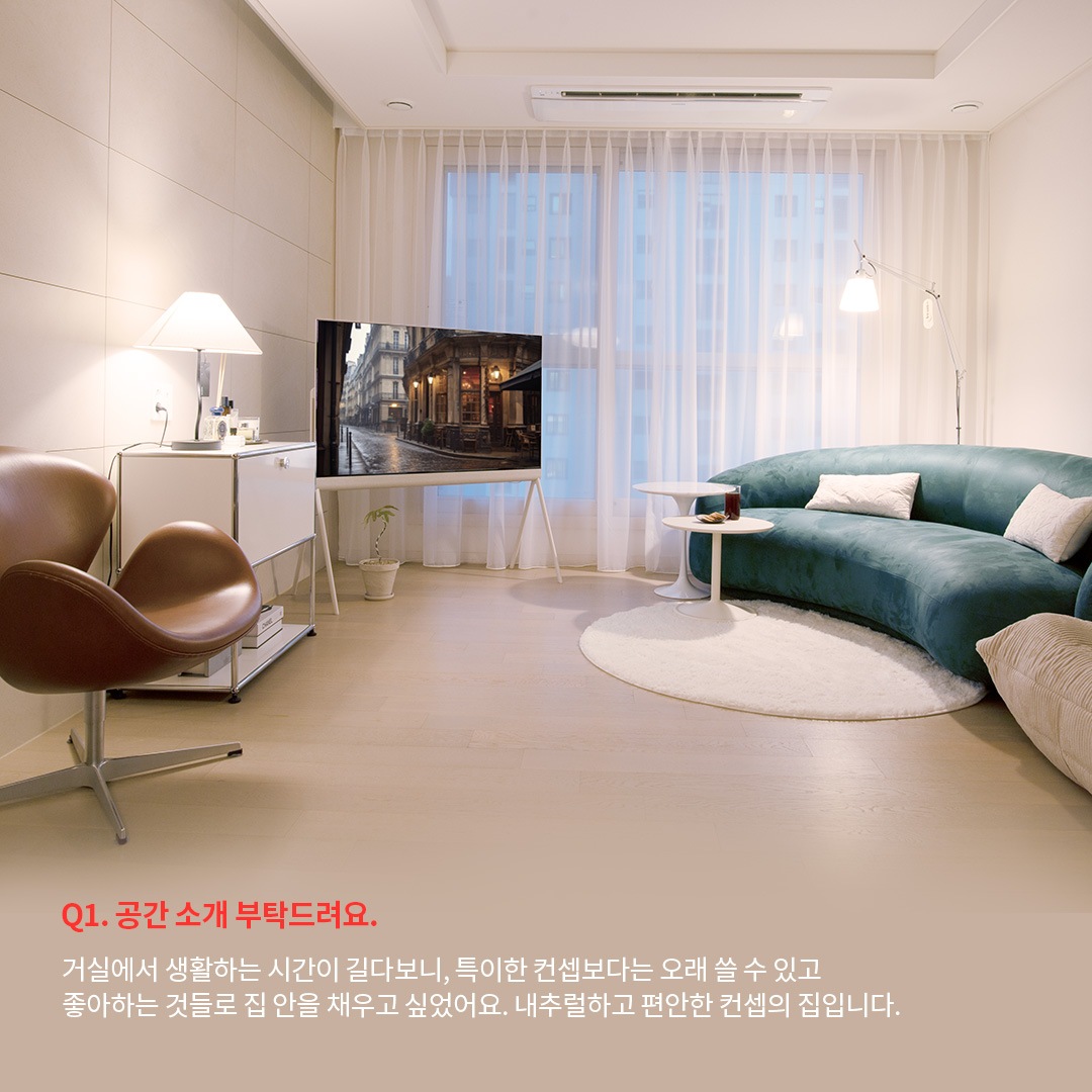 넓은 창과 따뜻한 조명 아래, 내추럴하고 편안한 분위기를 강조한 거실 공간입니다. 인터뷰 내용에서는 거실을 오래 쓸 수 있는 공간으로 구성하며, 개인의 취향과 편안함을 중시한 디자인 선택을 언급합니다.