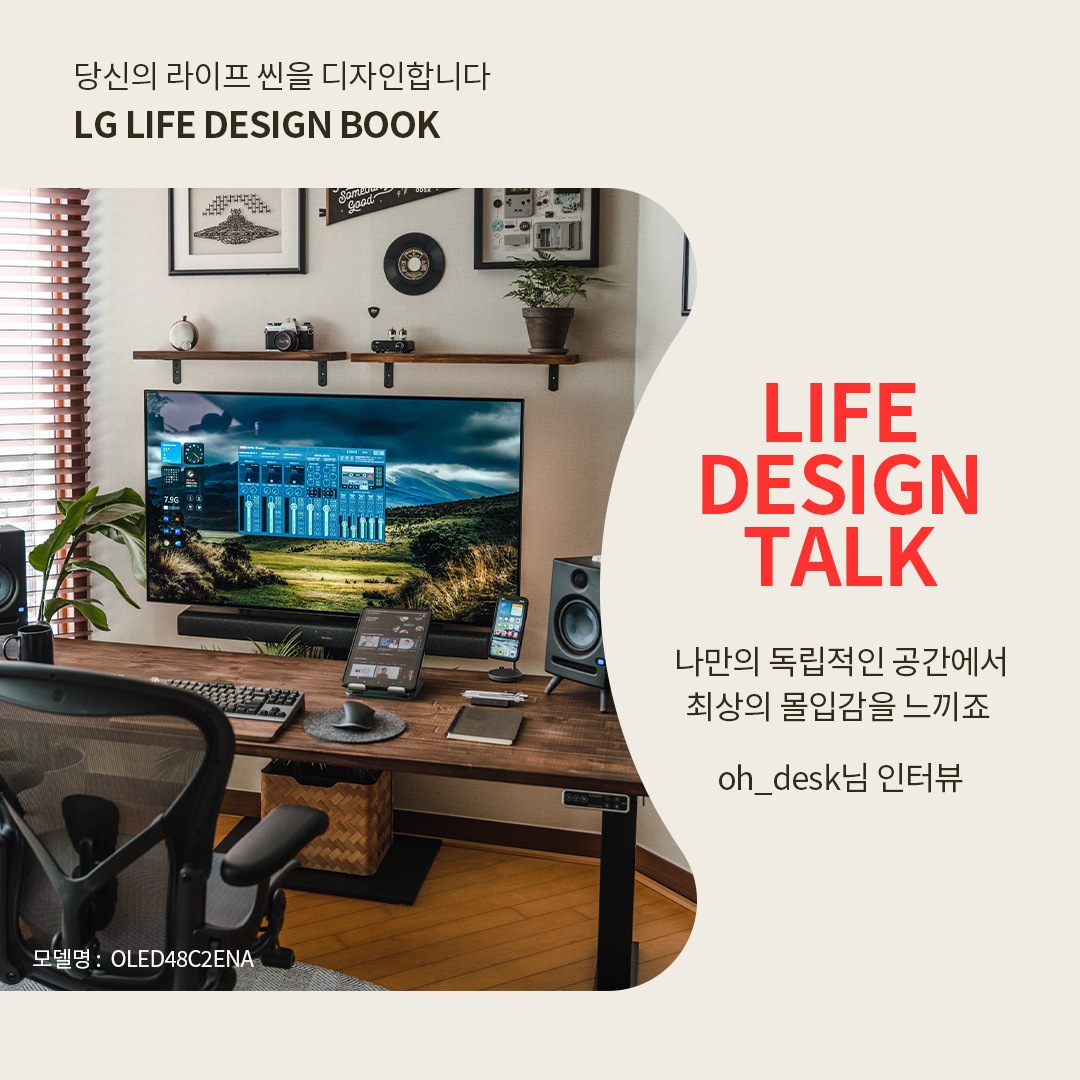 LG OLED TV를 활용한 독립적인 작업 및 엔터테인먼트 공간으로, 넓은 원목 책상 위에 키보드, 마우스, 태블릿, 스마트폰 등이 정리되어 있는 모습. 벽걸이형 모니터에는 자연 풍경과 오디오 조정 화면이 표시되며, 좌우에는 고급 스피커가 배치되어 최상의 몰입감을 제공하는 환경. 벽에는 시계, 카메라 장식, 식물이 놓인 선반이 조화를 이루며 감각적인 분위기를 연출하는 모습. 오른쪽에는 ‘당신의 라이프 씬을 디자인합니다. LG LIFE DESIGN BOOK. LIFE DESIGN TALK. 나만의 독립적인 공간에서 최상의 몰입감을 느끼죠. oh_desk님의 인터뷰’라는 문구가 포함된 이미지.