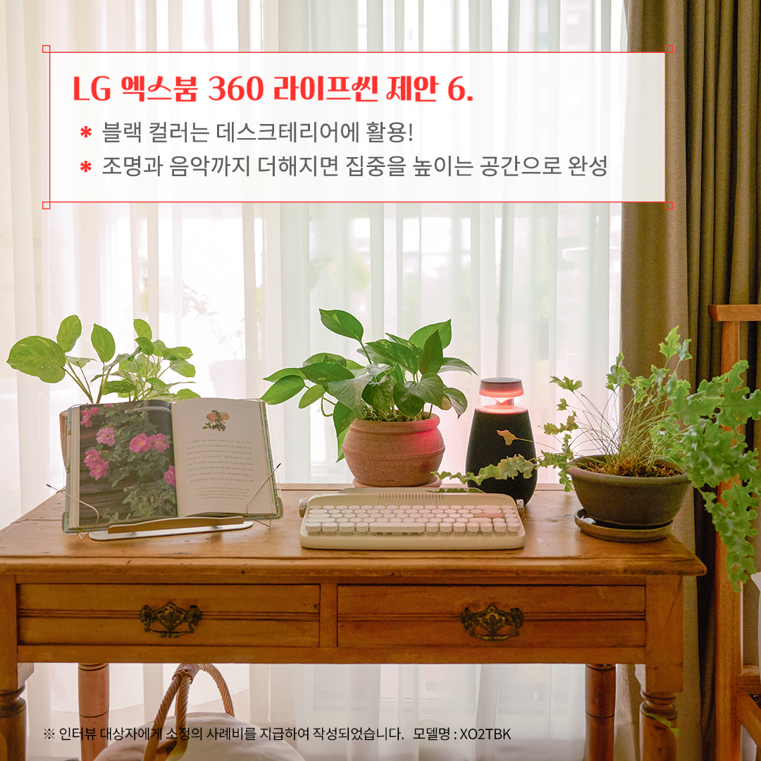 LG 엑스붐 360 라이프셋 제안 6. 블랙 컬러는 데스크테리어에 활용! 조명과 음악까지 더해지면 집중을 높이는 공간으로 완성 ※ 인터뷰 대상자에게 소정의 사례비를 지급하여 작성되었습니다. 모델명: XO2TBK 문구 표시됨. 배경은 우드 책상 위에 키보드, 오픈된 책, 블루투스 스피커, 여러 개의 화분이 놓여 있음. 배경에는 커튼과 창문이 있으며, 자연광이 들어와 따뜻하고 조용한 분위기를 연출함.