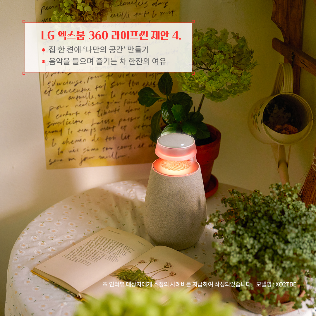 LG 엑스붐 360 라이프셋 제안 4. 집 한 켠에 ‘나만의 공간’ 만들기 음악을 들으며 즐기는 차 한잔의 여유 ※ 인터뷰 대상자에게 소정의 사례비를 지급하여 작성되었습니다. 모델명: XO2TBE 문구 표시됨. 배경은 둥근 테이블 위에 펼쳐진 책과 블루투스 스피커가 따뜻한 조명을 비추며 아늑한 분위기를 조성함. 주변에는 화분과 감성적인 벽 장식이 어우러져 자연스럽고 편안한 공간을 연출함.