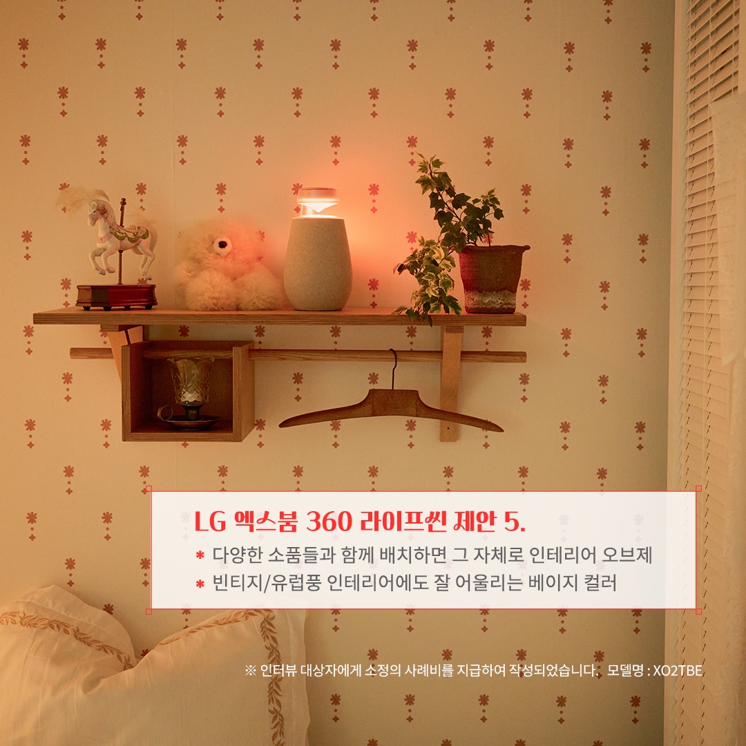 LG 엑스붐 360 라이프셋 제안 5. 다양한 소품들과 함께 배치하면 그 자체로 인테리어 오브제 빈티지/유럽풍 인테리어에도 잘 어울리는 베이지 컬러 ※ 인터뷰 대상자에게 소정의 사례비를 지급하여 작성되었습니다. 모델명: XO2TBE 문구 표시됨. 배경은 벽에 부착된 우드 선반 위에 블루투스 스피커와 식물, 인형, 장식품이 배치되어 따뜻한 조명과 함께 아늑한 분위기를 연출함. 베이지 톤의 벽지와 침구가 조화를 이루며 빈티지한 감성을 더함.
