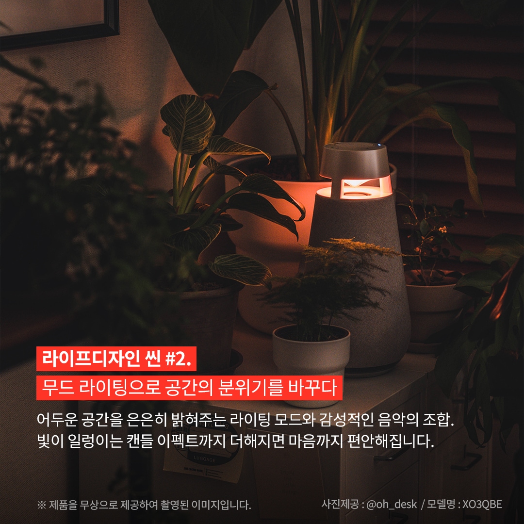 라이프디자인 씬 2. 무드 라이팅으로 공간의 분위기를 바꾸다 어두운 공간을 은은히 밝혀주는 라이팅 모드와 감성적인 음악의 조합. 빛이 일렁이는 캔들 이펙트까지 더해지면 마음까지 편안해집니다. ※ 제품을 무상으로 제공하여 촬영된 이미지입니다. 사진제공: @oh_desk / 모델명: XO3QBE 문구 표시됨. 배경은 어두운 공간, 실내 식물들 사이에 놓인 엑스붐 360 스피커. 스피커에서 나오는 붉은 빛이 식물들을 은은하게 비추고 있음.