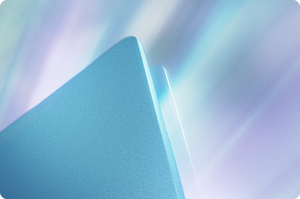 빛나는 푸른색 금속 질감의 노트북 측면을 근접 촬영한 이미지로, 세련된 디자인과 고급스러운 마감 품질을 강조함.