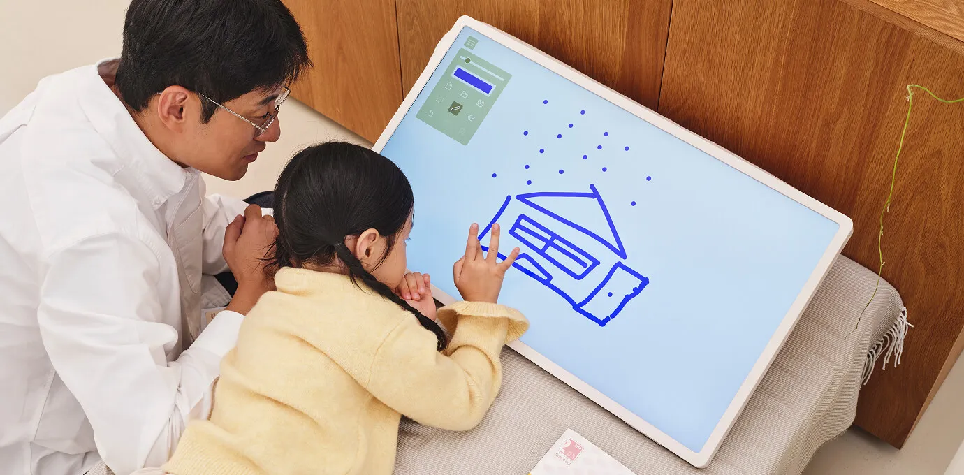 스탠바이미 2를 침대에 놓고 전자 칠판으로 활용하여 스크린 터치로 그림을 그리고 있는 여자아이