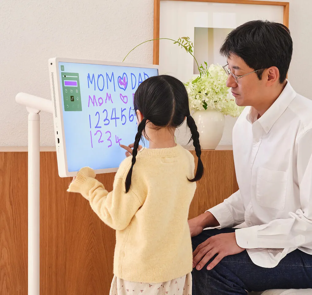 스탠바이미 2를 스탠드에 세워서 전자 칠판으로 활용하여 숫자 공부를 하는 여자아이