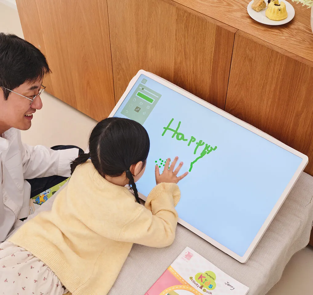 스탠바이미 2를 침대에 놓고 전자 칠판으로 활용하여 영어 공부를 하는 여자아이