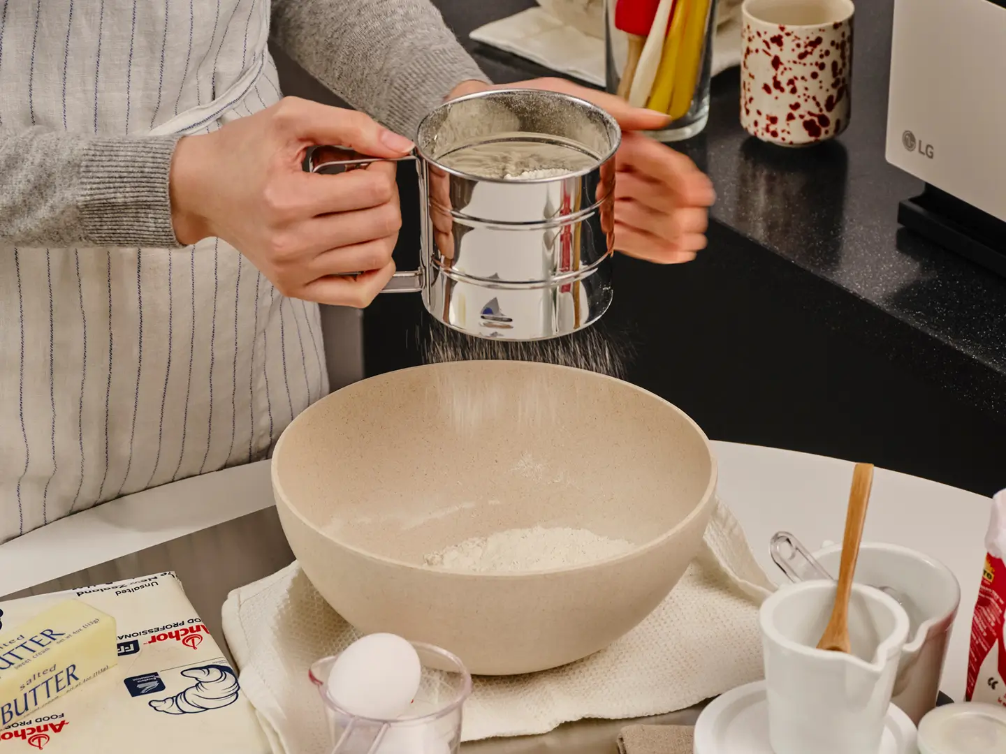 홈베이킹으로 크루아상을 만들기 위해 밀가루를 체치는 장면