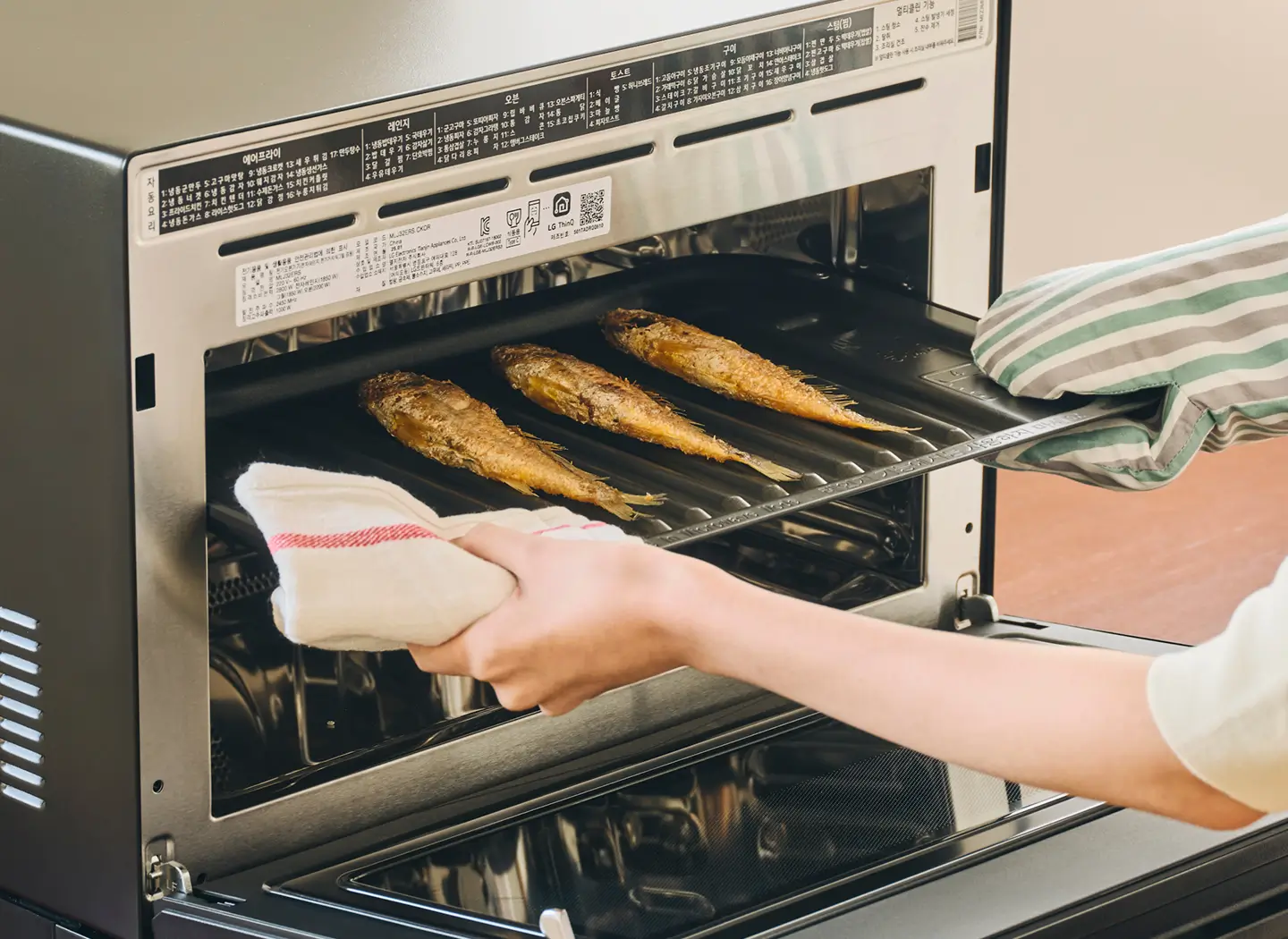 광파오븐에 조기를 구워 꺼내는 장면 