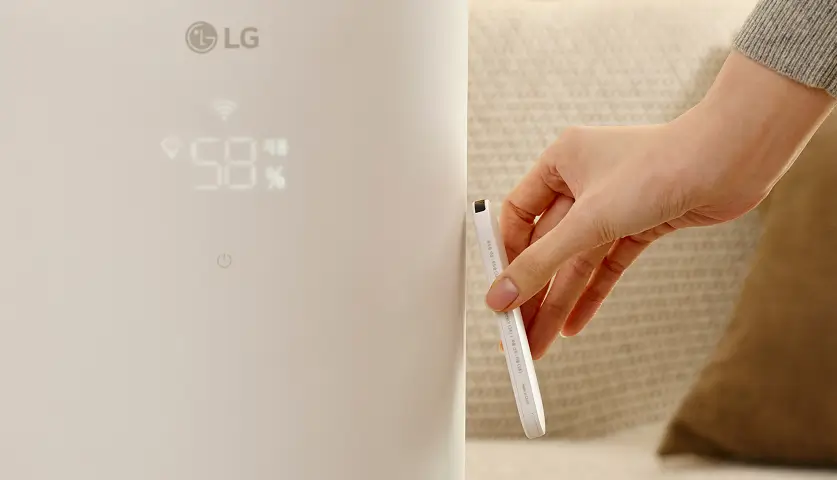 가습기 리모컨으로 모드와 습도를 설정하고, 사용하지 않을 때 하이드로에센셜에 붙이는 모습