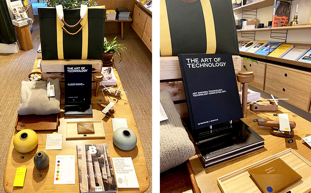 런던 모노클 매장 중앙 디스플레이 테이블에 『The Art of Technology』 책이 전시되어 있다. 블랙 커버의 책이 스탠드에 세워져 있으며, 주변에는 다양한 디자인 소품과 잡지가 함께 배치되어 있다. 니트 제품, 도자기 화병, 우드 소재의 비행기 장난감, 가죽 카드지갑 등이 정돈된 형태로 놓여 있어 감각적인 분위기를 연출한다.(왼쪽이미지) 런던 모노클 매장 중앙 테이블에서 『The Art of Technology』 책이 독립적으로 세워져 전시되어 있다. 책 주변에는 다양한 디자인 소품과 인테리어 소품들이 함께 진열되어 있으며, 우드 소재의 테이블과 따뜻한 조명이 매장의 세련된 분위기를 강조한다.(오른쪽이미지)