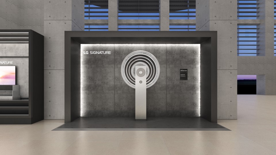 lg_signature_에어로타워_전시_공간._중앙에는_원형_패턴이_강조된_에어로타워가_놓여_있으며,_벽면에는_제품_정보가_적힌_패널이_설치되어_있다._세련된_조명과_입체적인_구조가_돋보이는_전시_부스.