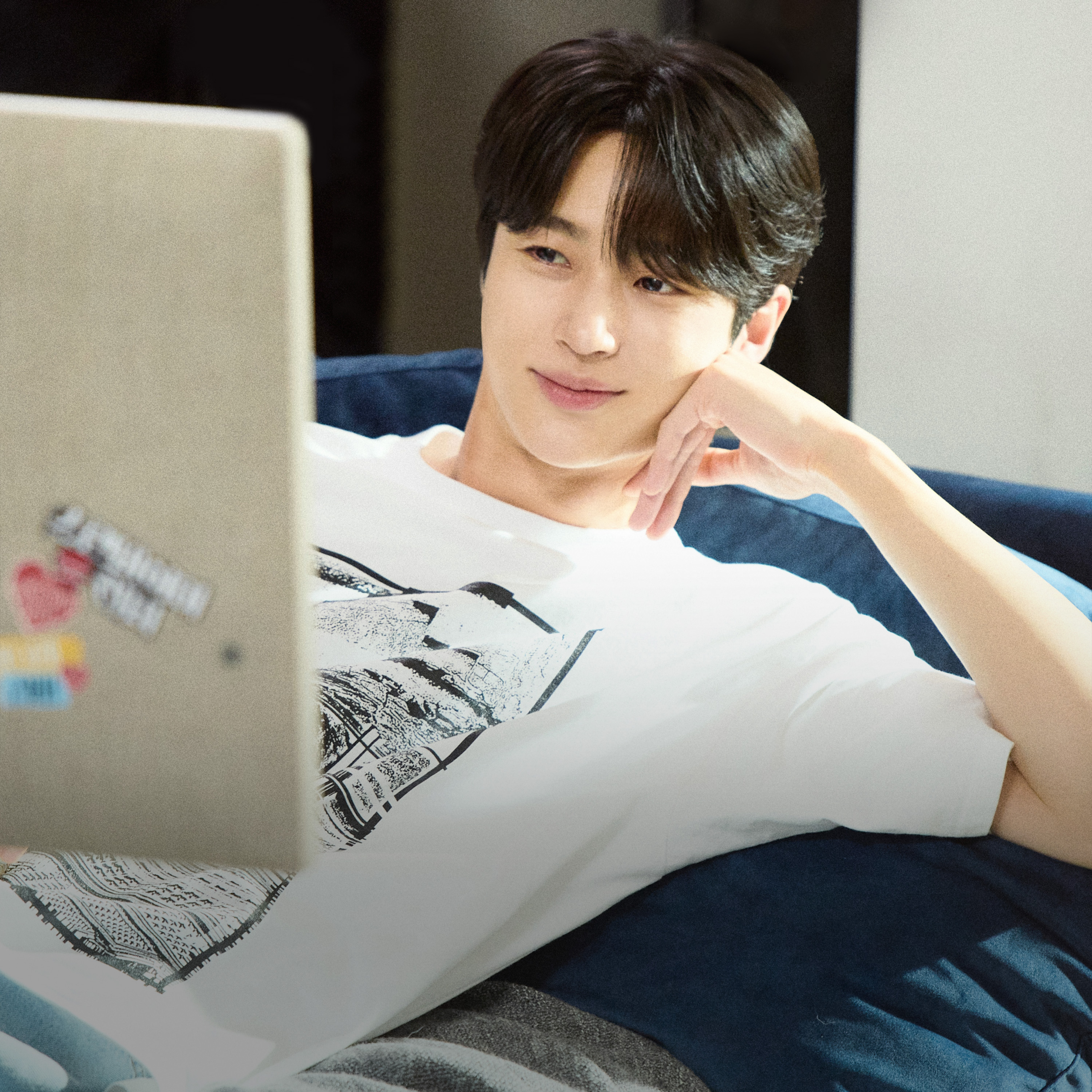 남성이_침대에_턱을_괴고_누운_채로_tv를_시청하고_있는_모습.