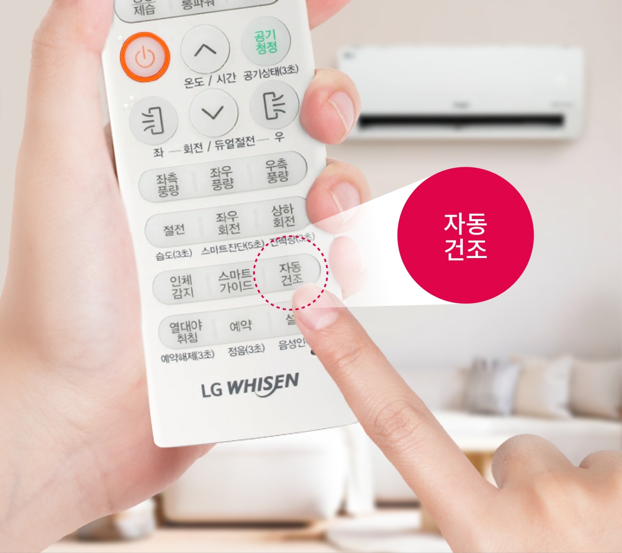 에어컨 리모컨의 '자동 건조' 버튼을 누르는 손과 배경에 보이는 실내 공간