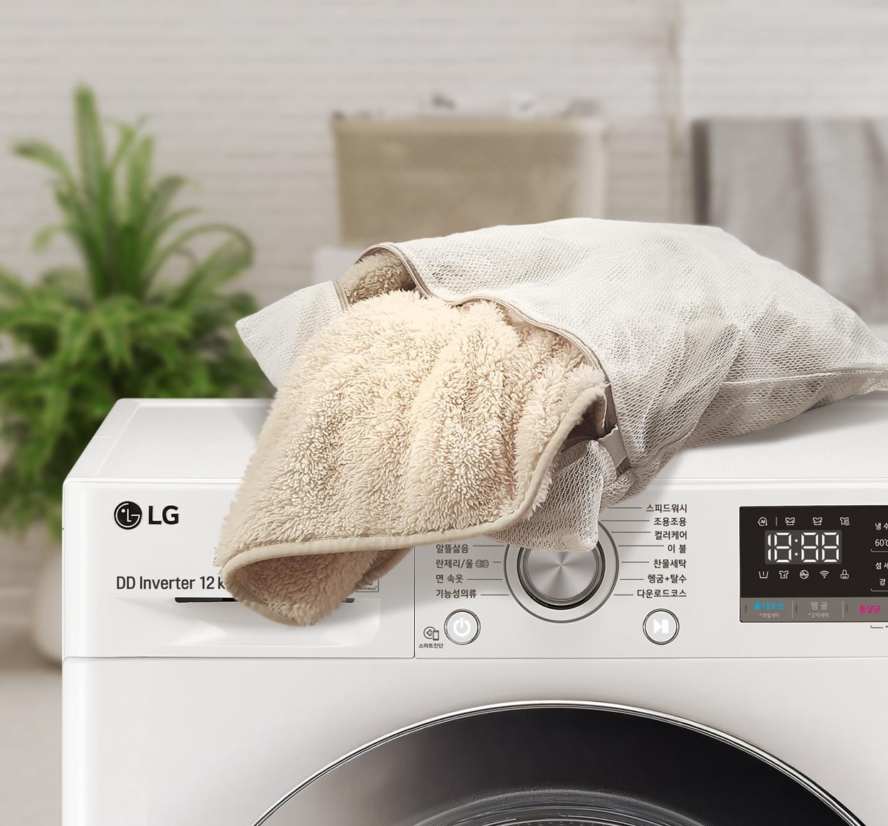 LG 세탁기 위에 세탁망 안에 담긴 베이지색 플리스가 놓여 있는 모습. 