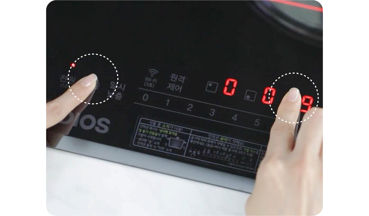 LG 디오스 인덕션 화면에서 한 손이 전원 버튼을, 다른 손이 숫자 9를 가리키는 모습.
