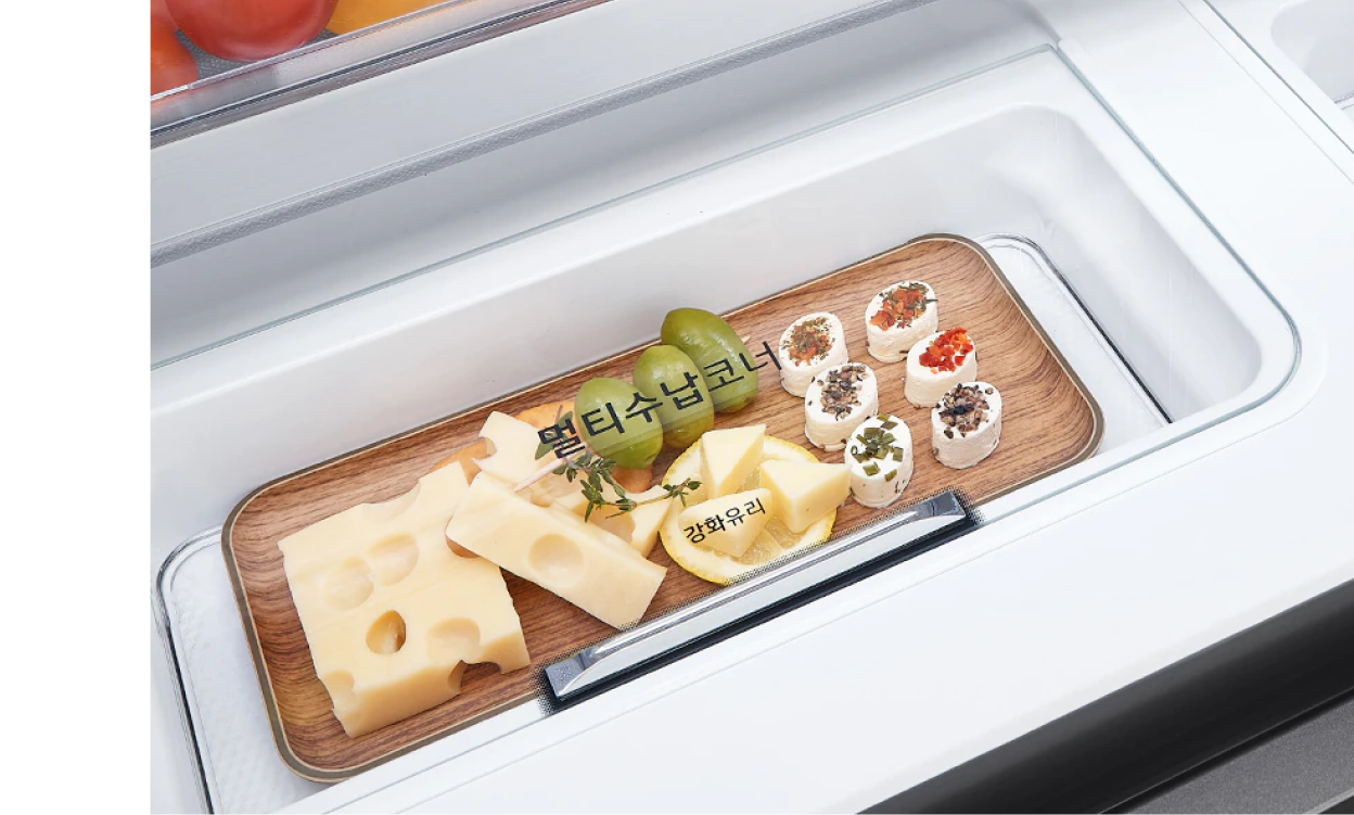멀티수납코너에 치즈, 과일 등 다양한 음식이 담긴 나무 트레이가 배치된 모습. '멀티수납코너'와 '강화유리' 텍스트가 표시됨.