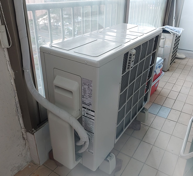 베란다 안쪽에 설치된 대형 에어컨 실외기, 배관이 실내로 연결됨