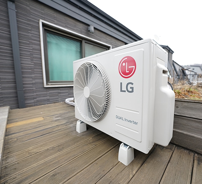 옥상 테라스에 설치된 LG 듀얼 인버터 실외기, 주변에 건물 창문이 보임