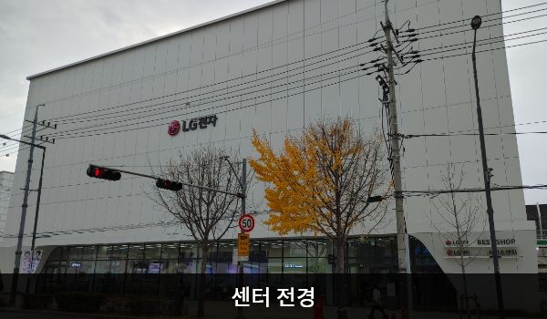 강북서비스센터의 서비스센터 건물은 높고 흰색이며 창문이 보이지 않습니다. 건물에 'LG전자'라고 쓰여 있습니다.