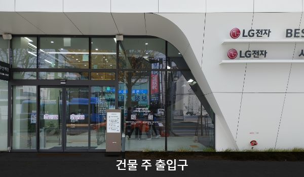 강북서비스센터의 대로 앞, 건물 오른쪽에 자동문 출입구가 있습니다. 문 앞에 점자블록이 있습니다.