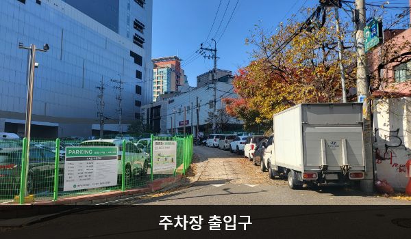 홍대역서비스센터의 주차장 출입구로 들어가는 골목이 좁습니다. 주차 차단기가 설치되어있고 건물 위쪽에 'LG전자' 문구가 적혀 있습니다.