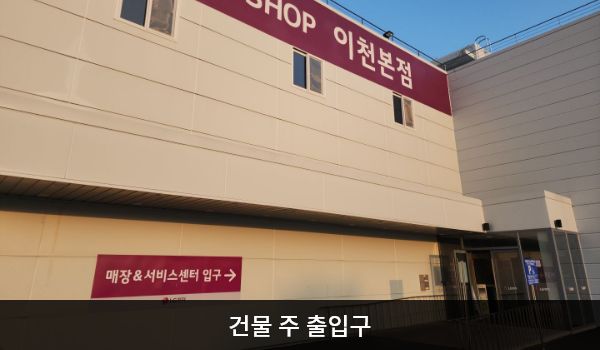 이천서비스센터의 건물 위쪽에 'LG전자 BEST SHOP 이천본점' 문구가 있고, 그 아래 1층 외벽에 '매장 & 서비스센터 입구'라는 문구가 적혀 있습니다. 그 오른쪽 방향에 주 출입구가 있습니다. 점자블록 앞의 유리문을 열고 들어가시면 자동문이 하나 더 있습니다.